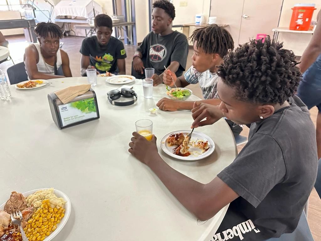 Youth sitting at a table having a meal