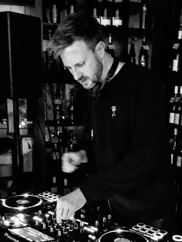 DJ am Mischpult in Schwarz-Weiß-Foto.