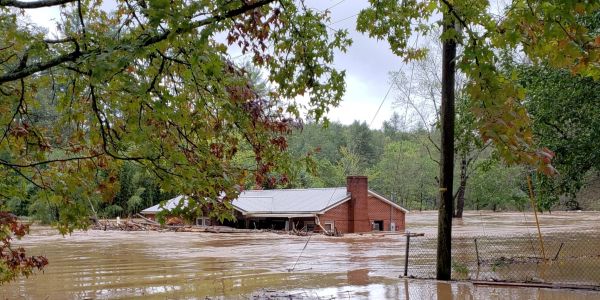 Flooded house nearly submerged in muddy water.