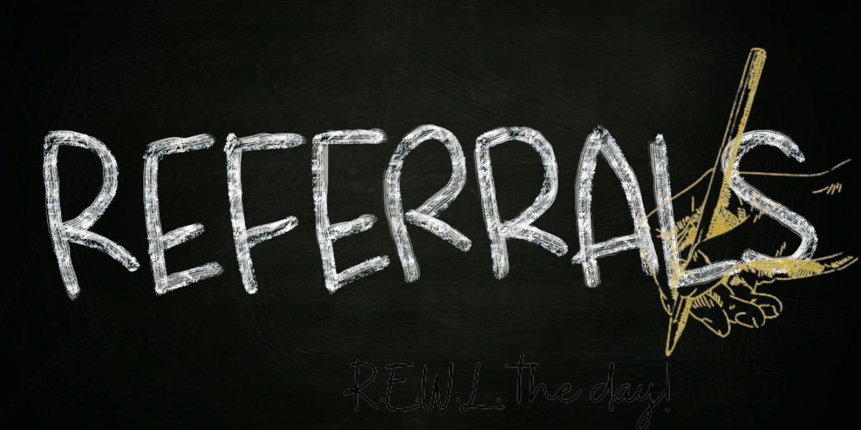 Word 'REFERRALS' written on a chalkboard with a hand drawing a pen.