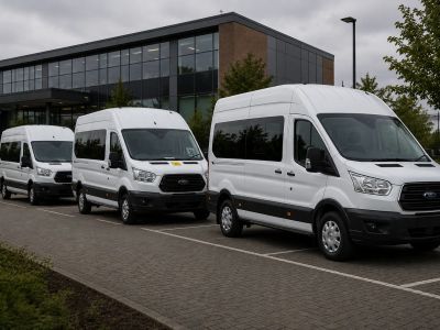 Three white passenger vans parked in a row.