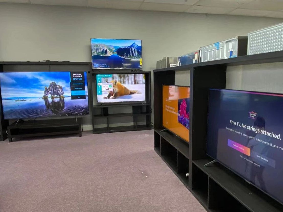 A room with multiple TVs displaying different screens and images.