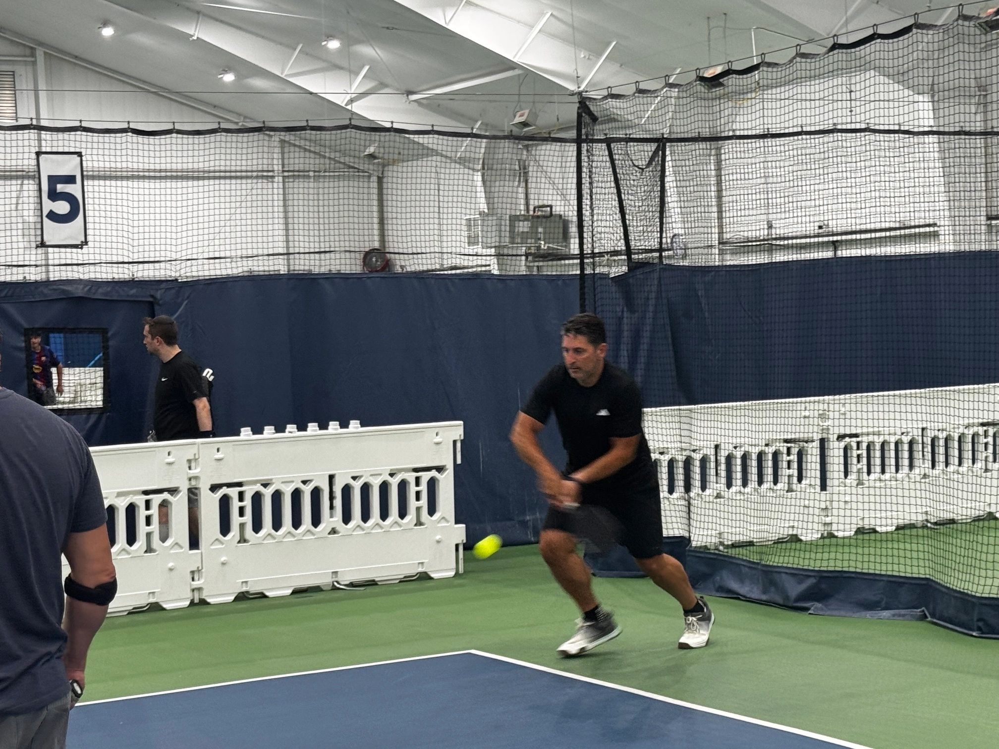 Man playing pickleball indoors.