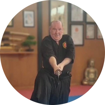 A man practicing martial arts with a sword indoors.