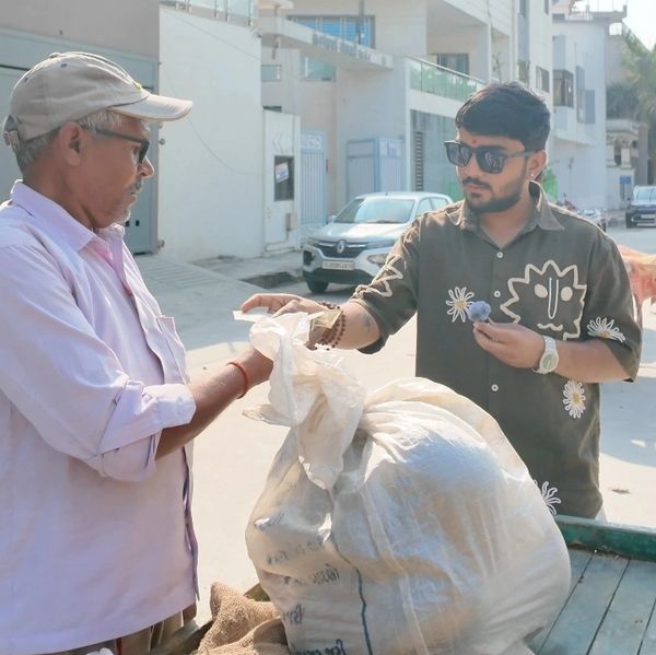 Young man handing money to an older man on the street.