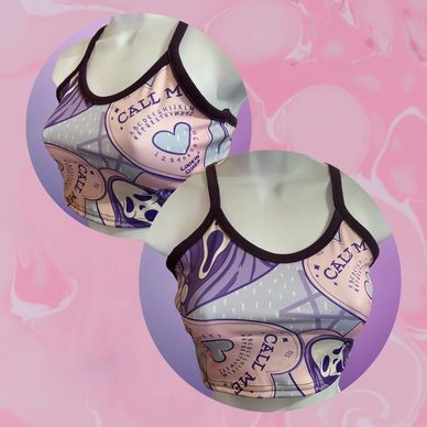 Stylish sports bra with a pastel, heart-themed design and black trim.