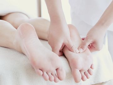 A person receiving a foot massage from a therapist.