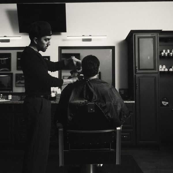 Barber giving a haircut in a stylish salon.