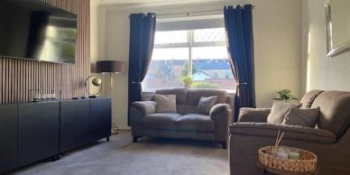 Cozy living room with gray sofas and large window.