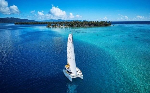 Catamaran sailing along a reef
