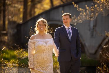 Happy couple holding hands outdoors with sunlight.