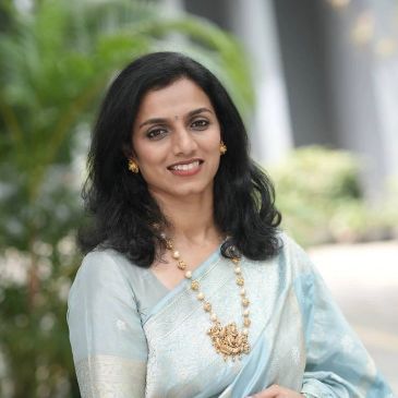 Smiling woman in traditional attire with jewelry.