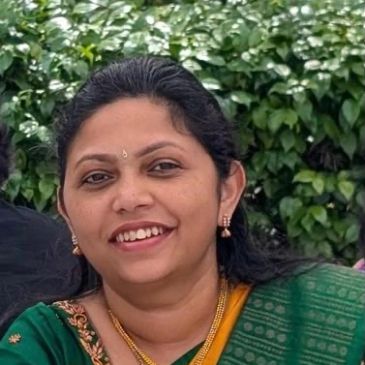 Smiling woman in traditional green attire.