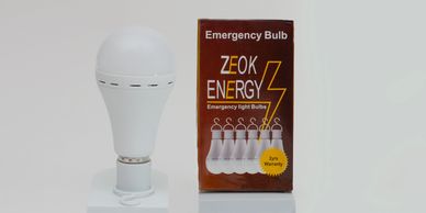 White emergency bulb next to its brown ZEOK ENERGY packaging box.