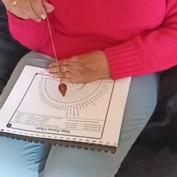 Rachel Sinclair performing Dowsing using a pendulum and a Dowsing chart