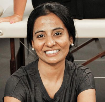 Smiling woman sitting, looking at the camera.