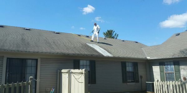 Person walking on a roof with a blue sky background.