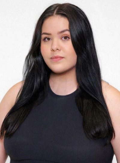 Young woman with long dark hair in a black top.
