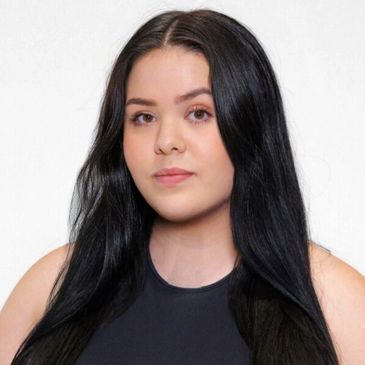 Young woman with long black hair in a black top.