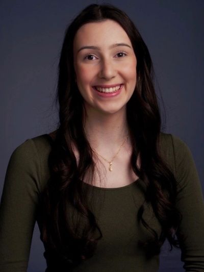 Young woman with long dark hair smiling.