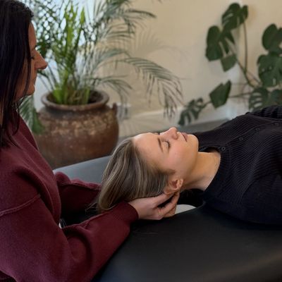 Person receiving a head massage or chiropractic adjustment.