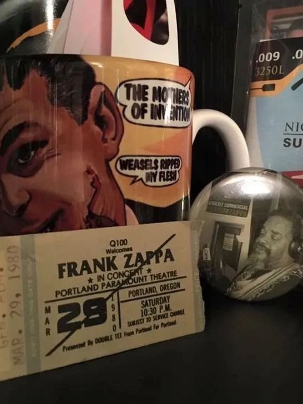 A mug with vintage comic art and various music accessories around it.