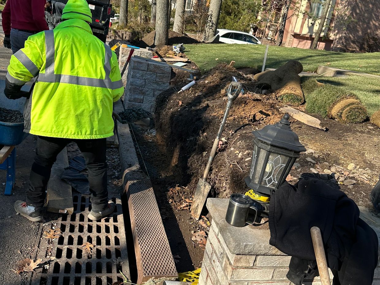 Construction workers in bright jackets working on retaining walls or landscaping.