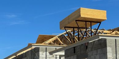 Wooden structure being built above a concrete building.