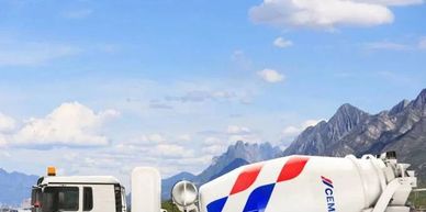 Concrete mixer truck on a road with mountains.