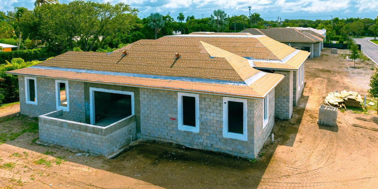 Unfinished house with exposed brick walls and roof under construction.