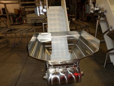 Stainless steel industrial conveyor system in a factory setting.