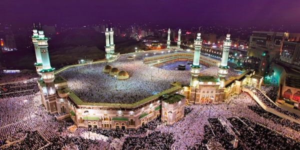 Aerial view of the Grand Mosque in Mecca filled with worshippers at night.