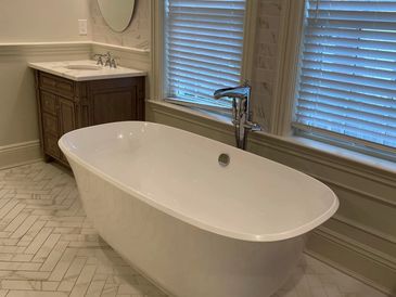 Modern bathroom with a freestanding bathtub and wooden vanity.
