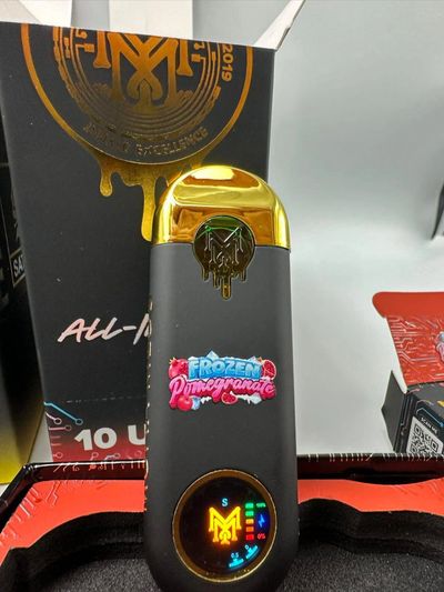 A sleek black and gold vaporizer with a colorful Frozen Pomegranate label.