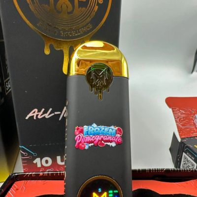 A sleek black and gold vaporizer with a colorful Frozen Pomegranate label.