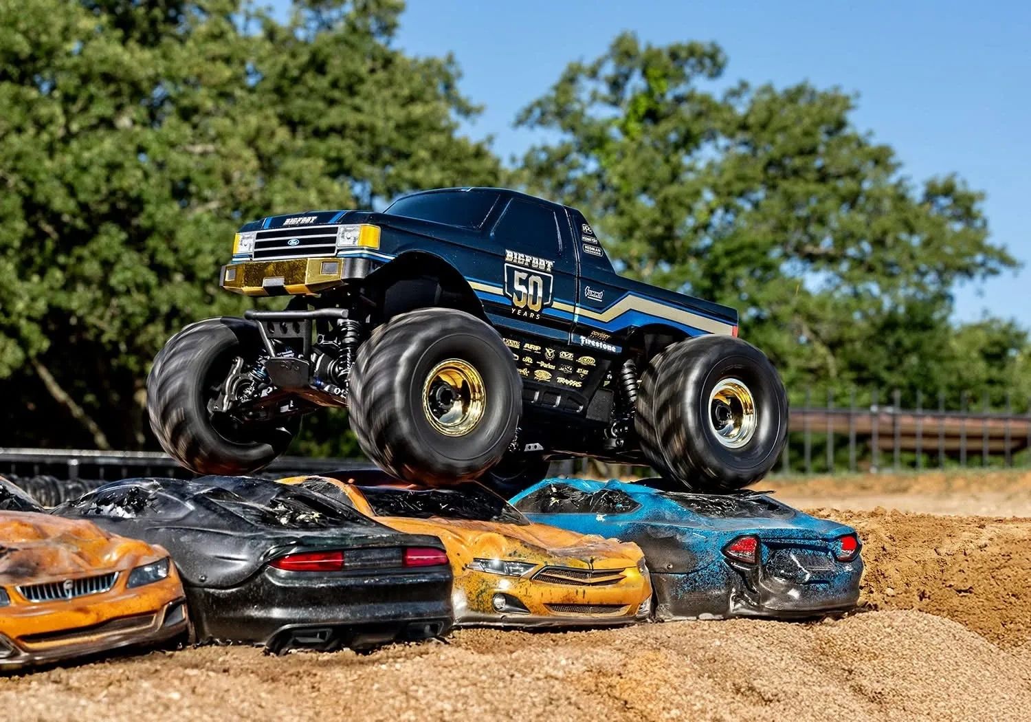 RC monster truck crushing toy cars outdoors.