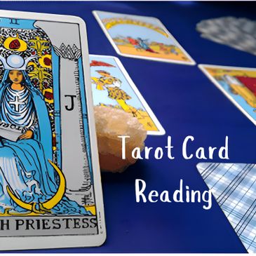 a man laying out the tarot cards on a table cover with a blue table cloth
