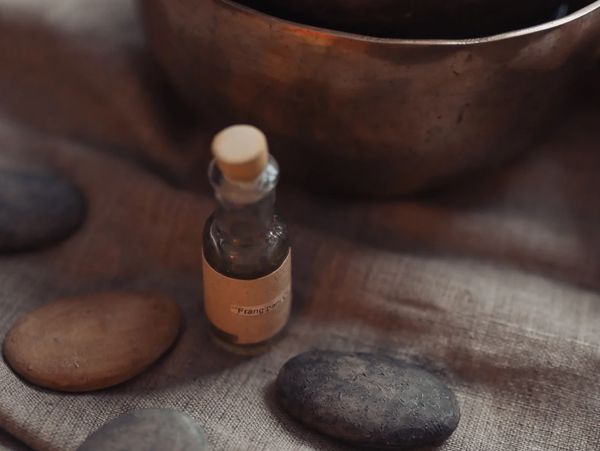 Kleines Fläschchen mit Korken und Steinen auf Stoff