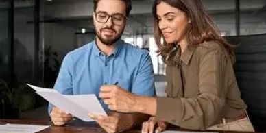 Two people discussing documents at a table.