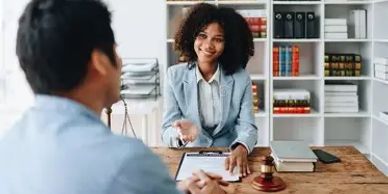 Lawyer consulting with a client across a desk.