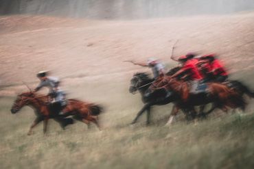 Blurry image of people horse riding.