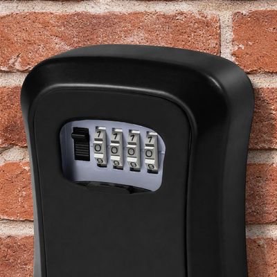 Black combination lock box mounted on a brick wall.