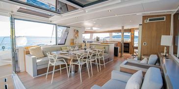 Spacious and modern yacht interior with dining and lounging areas.