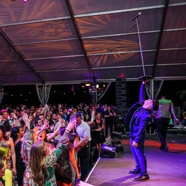 Robby Celestin performs his signature one-handed microphone stand balance during a live performance,