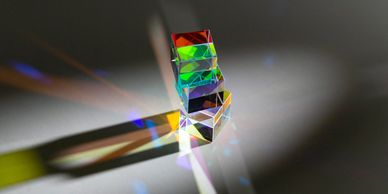 A glass prism dispersing light into colorful spectra.