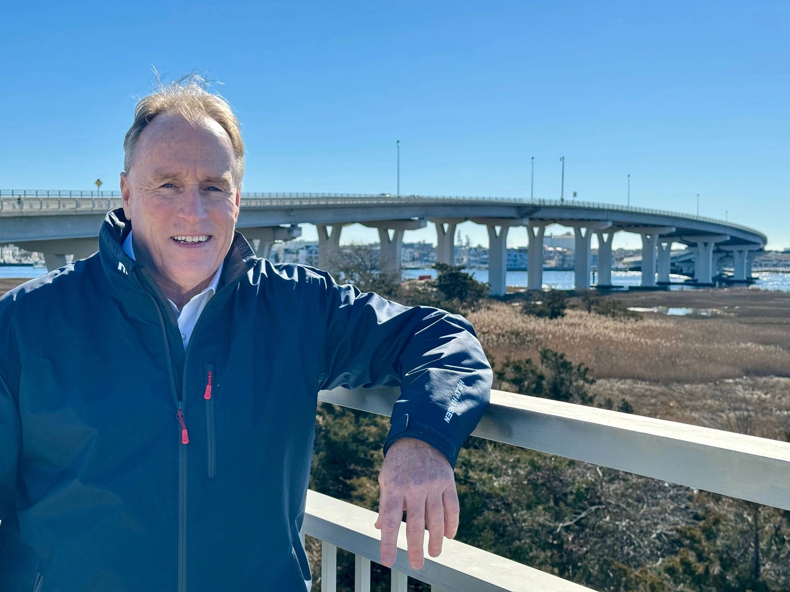 A man taking picture with behind the bridge