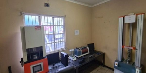Small laboratory room with testing machines and office chair.