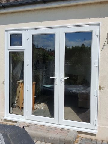 a set of white uPVC double glazed french doors and uPVC double glazed side light