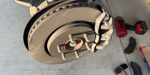 Close-up of a car's brake rotor and caliper during maintenance.