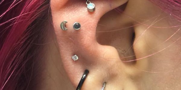 Ear with multiple piercings and jewelry.